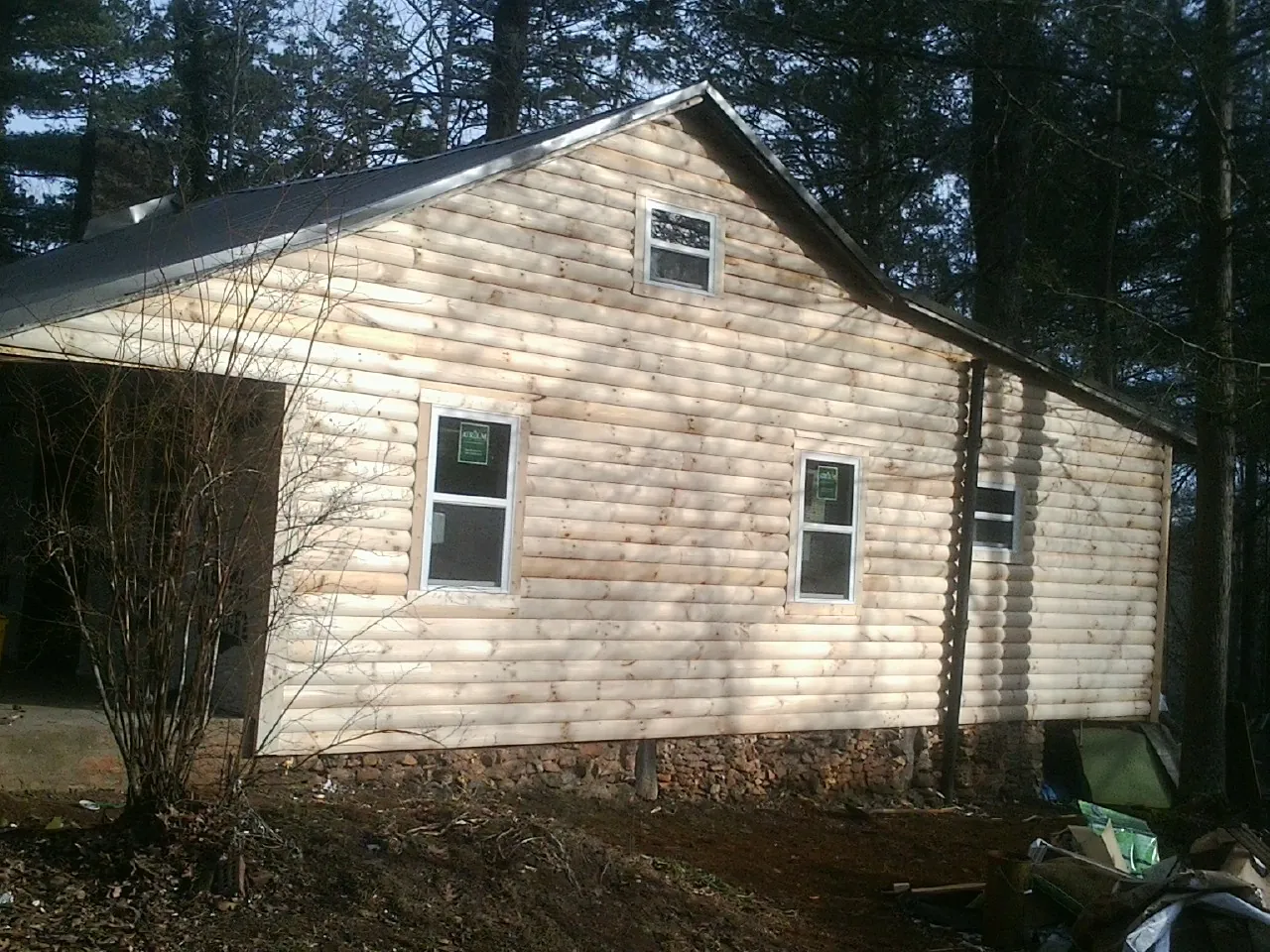 New log siding and dark metal roofing on a gable end in Bell Buckle