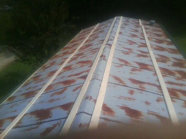 Rusted metal roof panels with new wood purlins before replacement — Storm Damage Roof Repair in Bell Buckle by Roofing Brothers